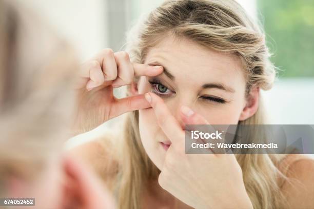 Young Woman Applying Contact Lens Stock Photo - Download Image Now - Contact Lens, Women, Inserting