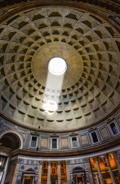 Interior of the Pantheon in Rome Rome, Italy, march 2017: The Pantheon  is a former Roman temple, now a church, in Rome. The building is circular with a portico of large granite Corinthian columns under a pediment. A rectangular vestibule links the porch to the rotunda, which is under a coffered concrete dome, with a central opening (oculus) to the sky. Almost two thousand years after it was built, the Pantheon's dome is still the world's largest unreinforced concrete dome. The height to the oculus and the diameter of the interior circle are the same, 142 feet rotunda photos stock pictures, royalty-free photos & images