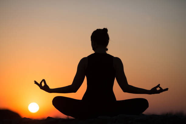 istock Slim woman doing yoga over orange sun 674062648