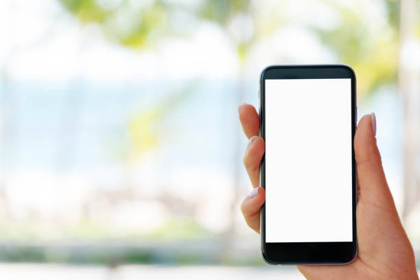 istock Beautiful woman's hand using smart phone at beach. Smartphone white screen.Blank empty screen 674062790