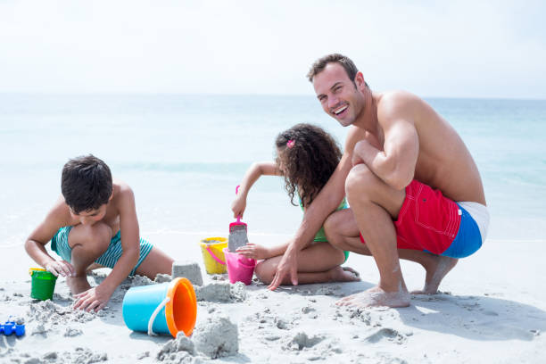 istock Happy father enjoying with children at beach 674062884