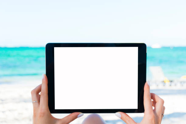 istock Blank empty tablet computer in the hands of girl on the beach, space for text 674062980