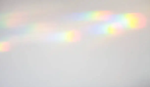 Refracted light falling on a wall, and creating spectrum patterns of colour.