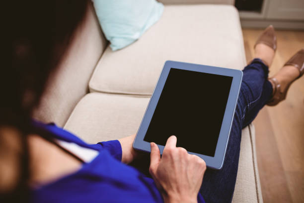 istock Rear view of woman using digital tablet 674078876