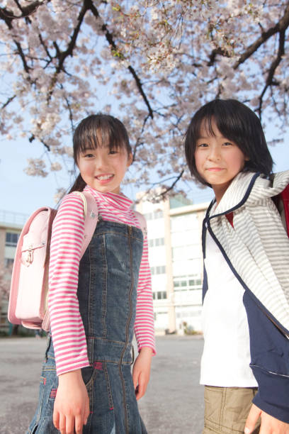 istock Two girls look back and smile 674090246