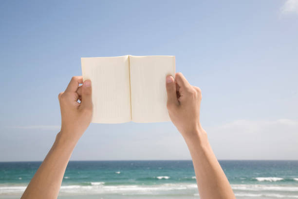 istock Arms of the men read a paperback book 674090528
