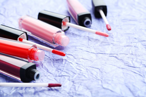 istock Colorful lip gloss on blue paper background 674090844