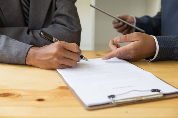 istock businessman poting his finger at contract - presenting & signing business document with partner 674091718