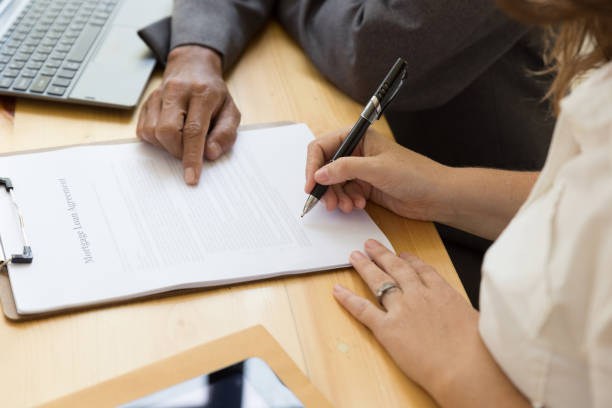 istock Person's hand hold ballpoint pen writing on  agreement paper sheet, fill in document template, applying for mortgage loan 674091736