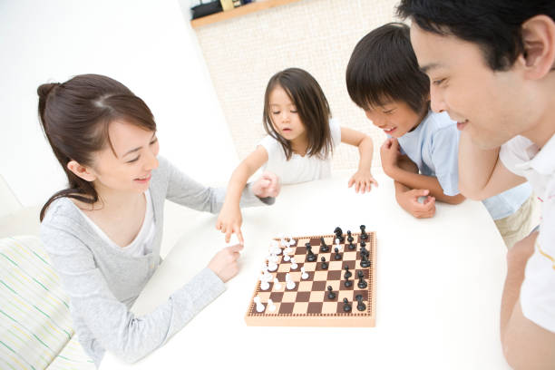 チェスファミリ - board game playing child family ストックフォトと画像