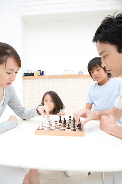 チェスファミリ - board game playing child family ストックフォトと画像