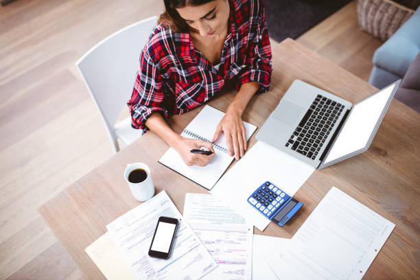 istock High angle view of woman writing in notepad 674114008