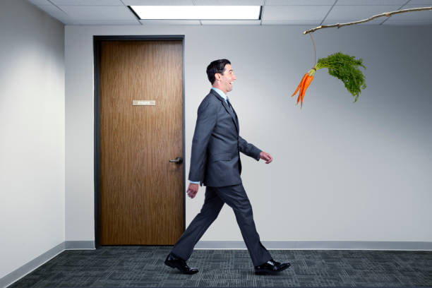 istock Businessman Following Dangling Carrot In Office 674115664
