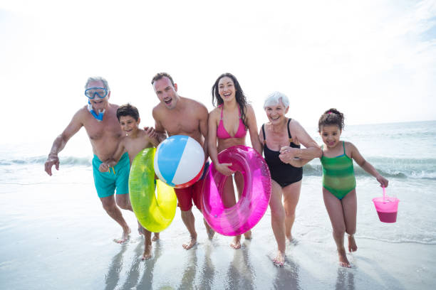 Happy multi-generation family running at beach