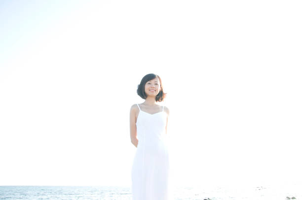 istock Woman standing on the beach 674115998
