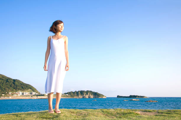 istock Woman standing on the beach 674116078