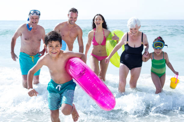 istock Multi-generation family running at beach 674116088