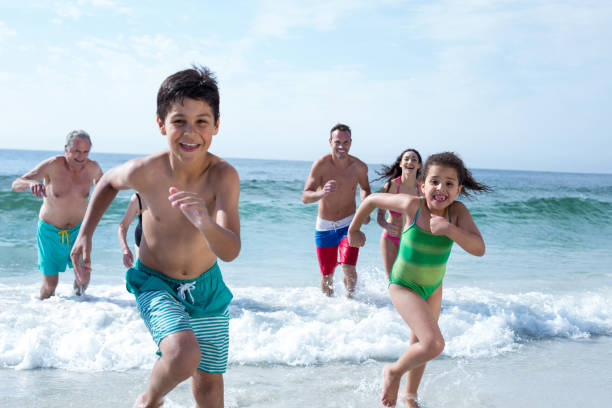 istock Parents running behind children at beach 674116432