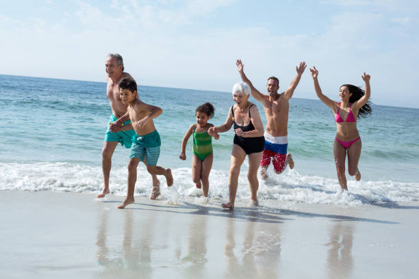 istock Multi-generation family running at beach 674116948