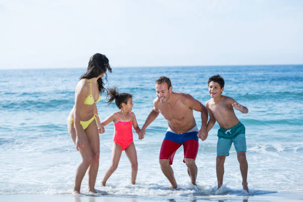 istock Family in swimwear holding hands while enjoying 674122188