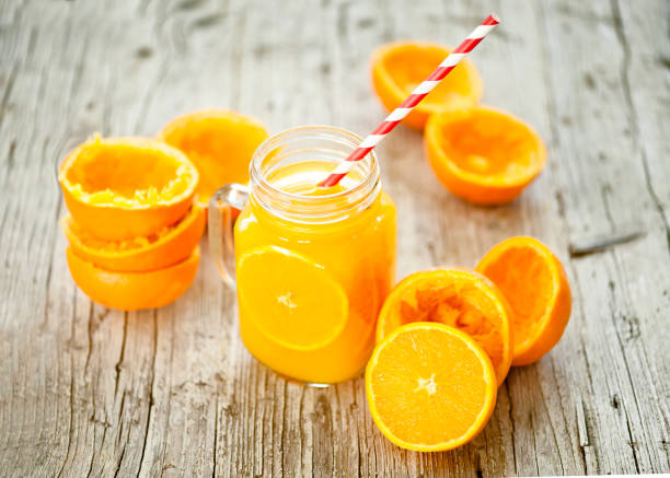 Orange Juice Squeezed In glass jar with fund rustic Orange juice in glass jar on wooden table proteína stock pictures, royalty-free photos & images