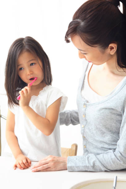 istock Mother with girl brushing teeth. 674139470