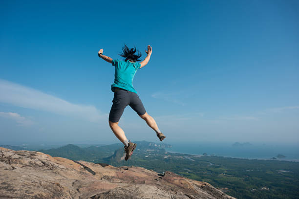 istock jumping on rocky mountain peak, freedom, risk, challenge, success concept 674139742