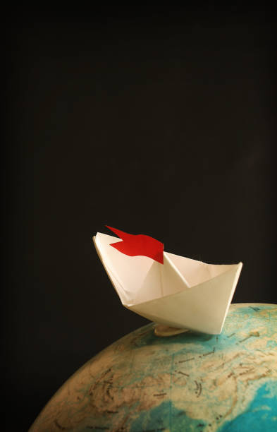 istock Travel concept with globe and paper boat 674140498