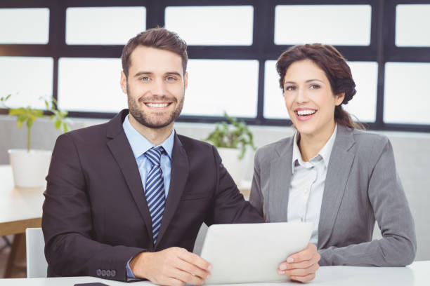 istock Happy business people with digital tablet in office 674146360