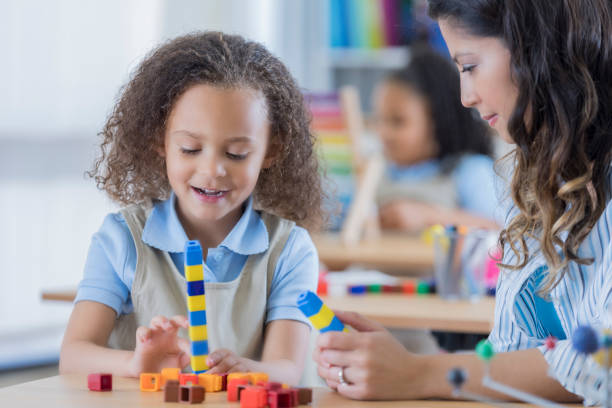 istock Adorable mixed race student uses counting cubes 674147010