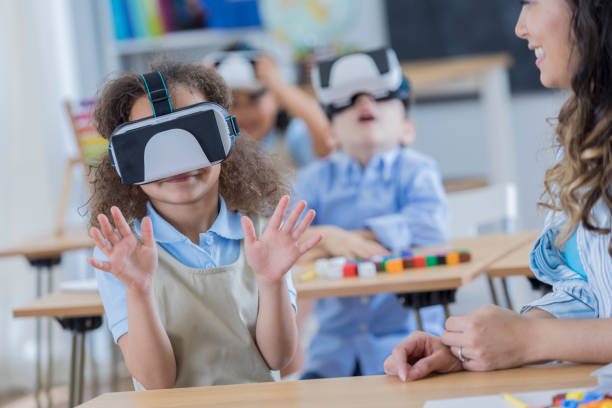 istock Happy girl uses virtual reality goggles at school 674147036