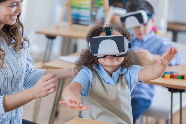 istock Little girl reaches out while using virtual reality goggles 674147064