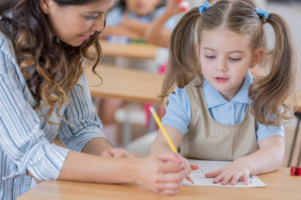istock Little girl works on worksheet in kindergarten class 674147192