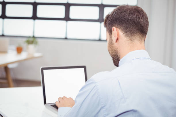 istock Businessman working on laptop at desk in office 674147462