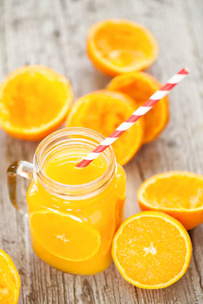 Orange juice in glass jar on wooden table