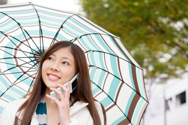 istock Women talk on the cell phone, umbrella 674152562