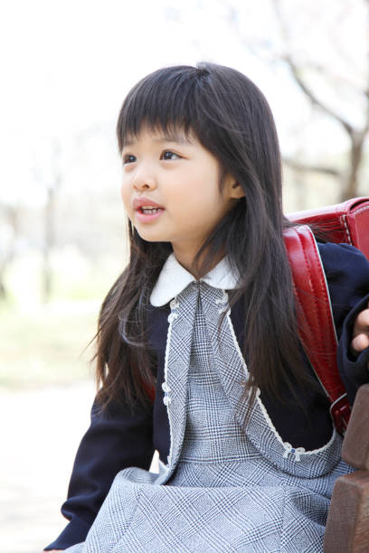 istock Elementary school girls sit on the bench in Cherry 674154334