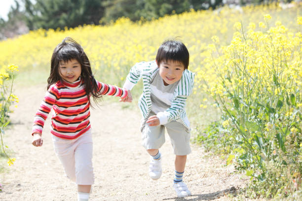 istock Elementary school men and women running in rape field 674156760