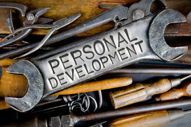 Photo of various tools and instruments with PERSONAL DEVELOPMENT letters imprinted on a clear wrench surface