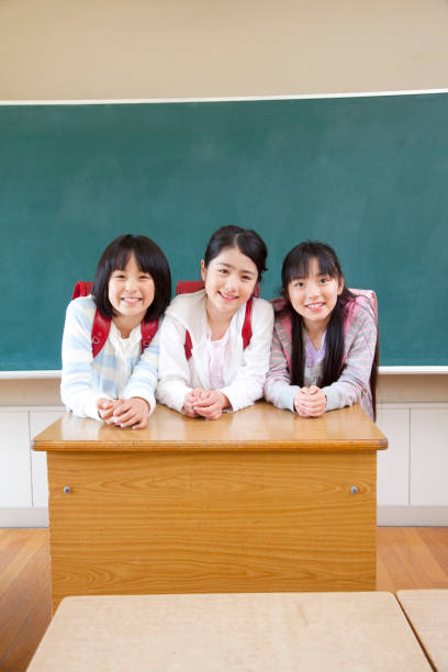 istock Three elementary school girls smiling in front of the Blackboard 674165068
