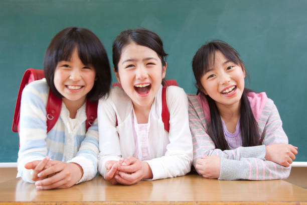 istock Three elementary school girls smiling in front of the Blackboard 674165156