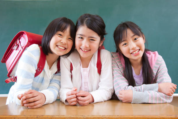 istock Three elementary school girls smiling in front of the Blackboard 674165180