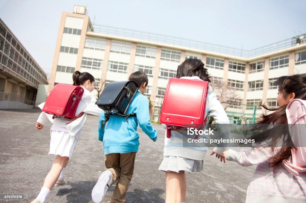 Rear view of the elementary school students go to school four Elementary School Stock Photo