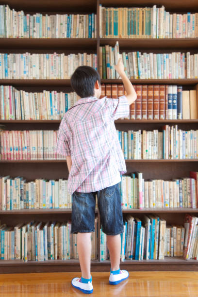 istock Back in elementary school boys find books in the library 674170582