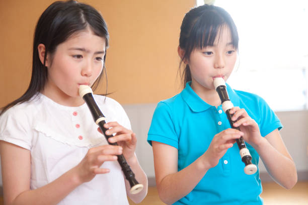 istock Elementary school girls blow the recorder 674171288