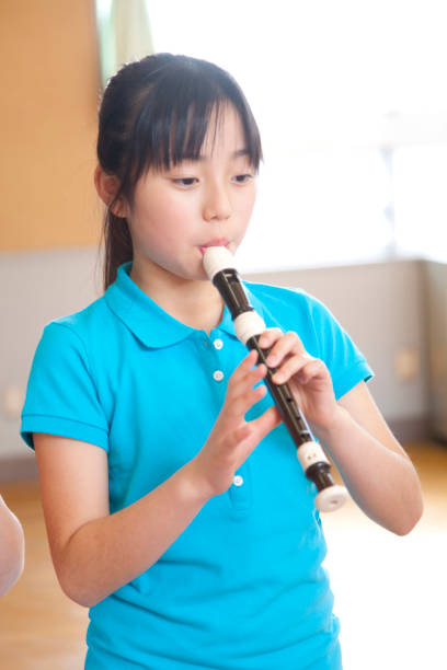 istock Elementary school girls blow the recorder 674171304