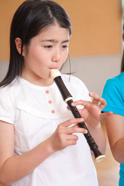 istock Elementary school girls blow the recorder 674171314