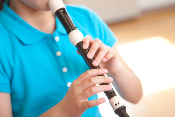 istock Elementary school girls blow the recorder 674171324