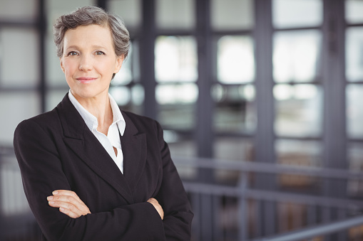 Portrait of confident businesswoman standing by railing in office