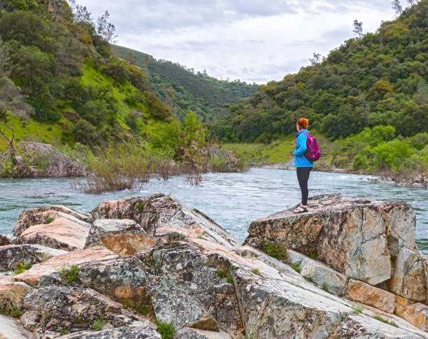 istock Girl Standing on Rocks Near Fast River 674181448